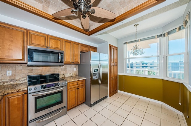 kitchen with brown cabinets, stainless steel appliances, decorative backsplash, and decorative light fixtures