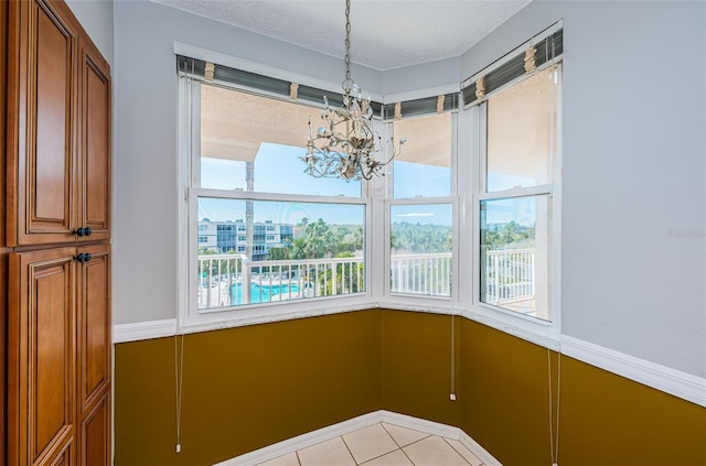 unfurnished dining area with a textured ceiling and an inviting chandelier