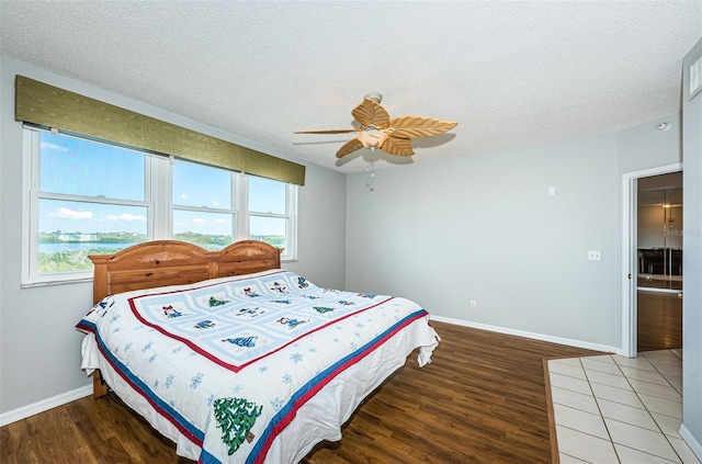 bedroom featuring a textured ceiling, multiple windows, and light wood-type flooring