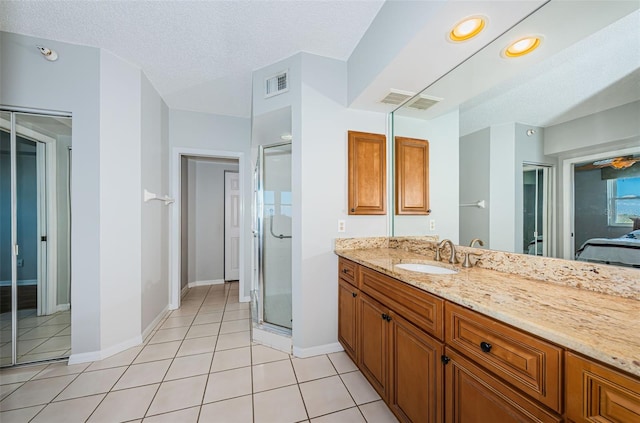 bathroom featuring visible vents, a shower stall, vanity, a textured ceiling, and tile patterned flooring