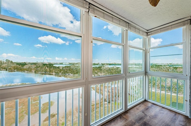 unfurnished sunroom featuring a water view