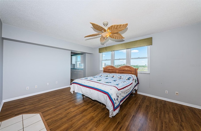 bedroom with a ceiling fan, a textured ceiling, baseboards, and wood finished floors