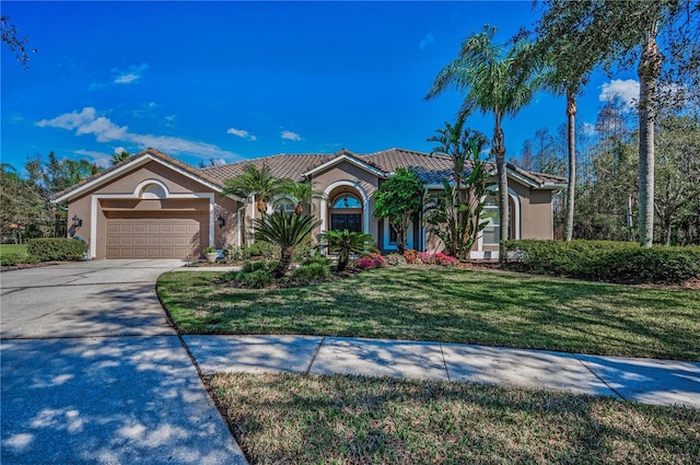 mediterranean / spanish-style house featuring a garage and a front lawn