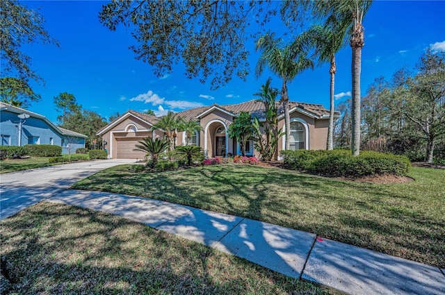 mediterranean / spanish home with a garage and a front lawn