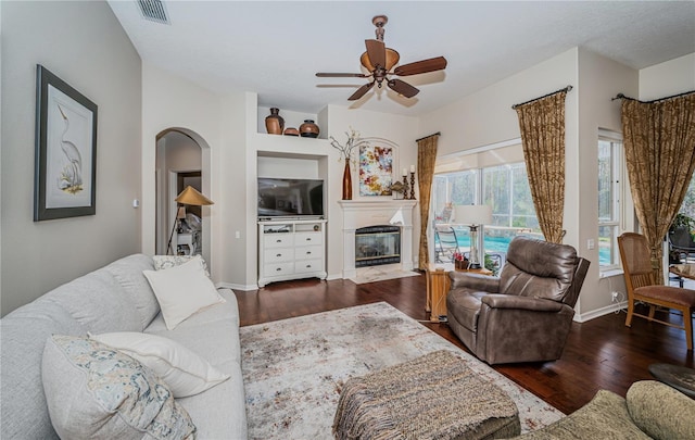 living room featuring dark wood-type flooring and ceiling fan