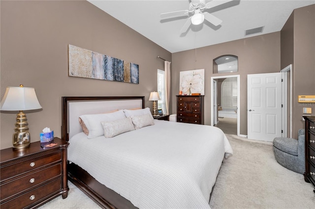 carpeted bedroom featuring ensuite bath and ceiling fan