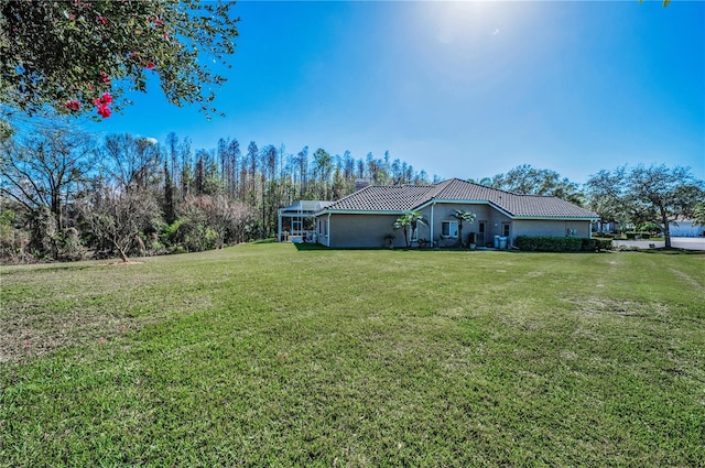 view of front of home with a front yard and glass enclosure