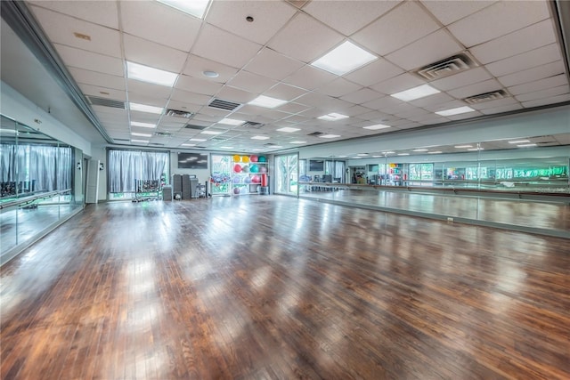 workout area featuring hardwood / wood-style floors and a drop ceiling