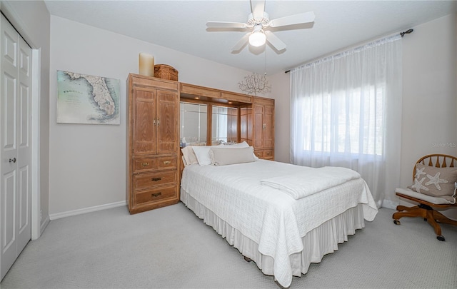 bedroom with light colored carpet, a closet, and ceiling fan