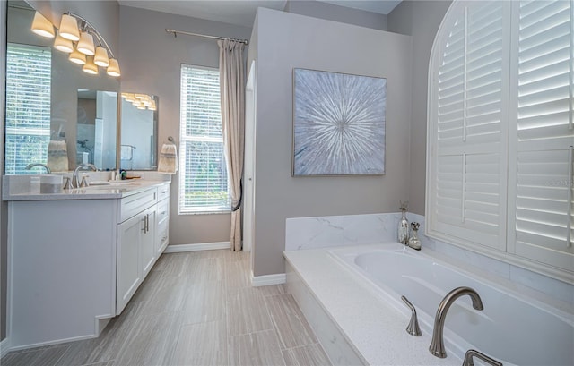 bathroom with vanity and tiled tub