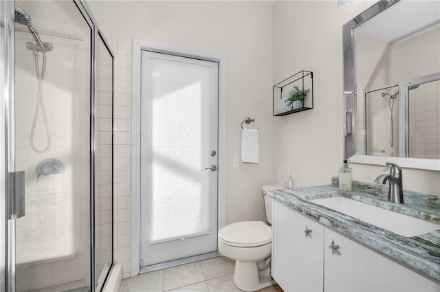 bathroom with an enclosed shower, vanity, tile patterned floors, and toilet