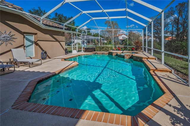 view of pool with an in ground hot tub, glass enclosure, and a patio area