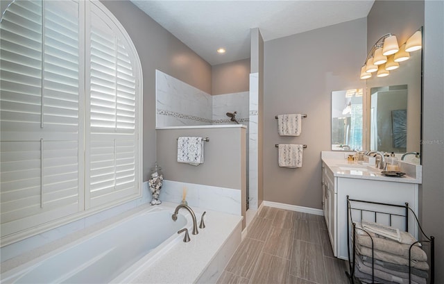 9101 Highland Ridge Way, Tampa, FL 33647 - bathroom with a bath, vanity, walk in shower, baseboards, and plenty of natural light