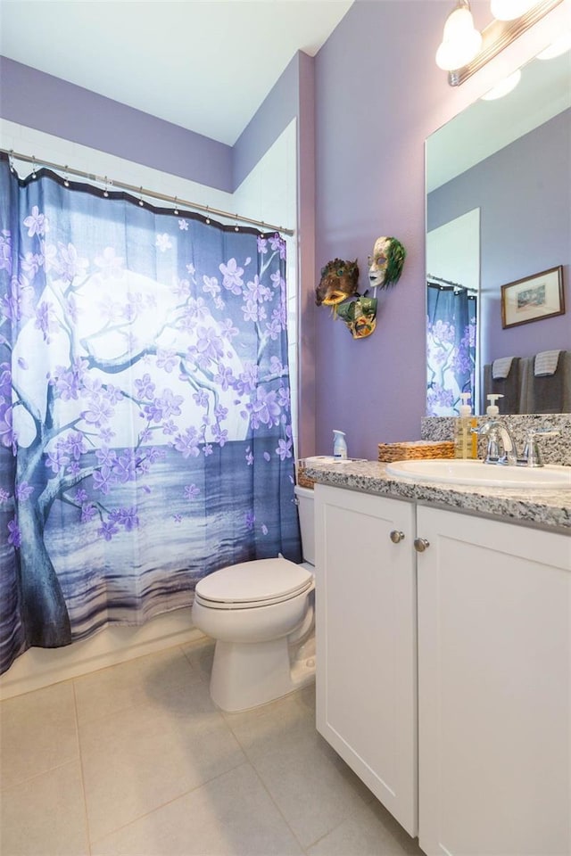 bathroom with a shower with curtain, vanity, tile patterned floors, and toilet