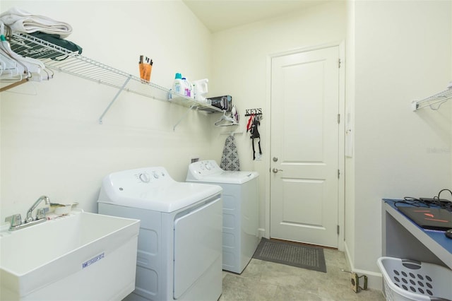 clothes washing area with separate washer and dryer and sink