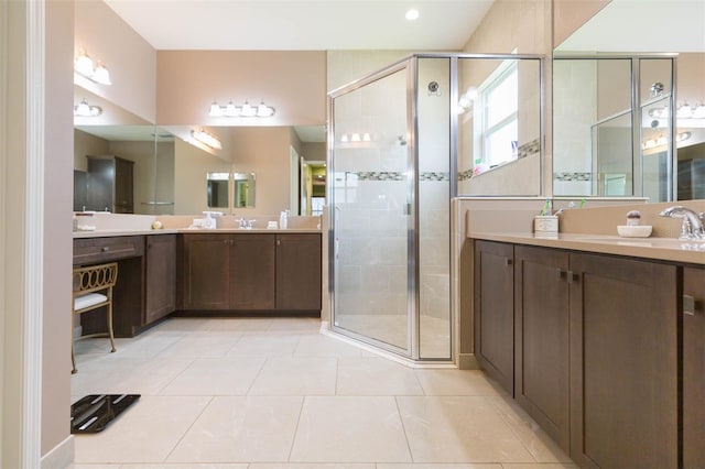 bathroom with an enclosed shower, vanity, and tile patterned flooring