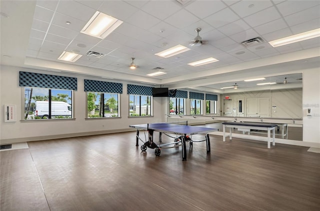 recreation room with hardwood / wood-style floors, a paneled ceiling, ceiling fan, and a tray ceiling