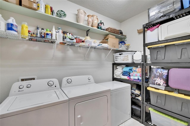 washroom with laundry area, a textured ceiling, and washing machine and clothes dryer