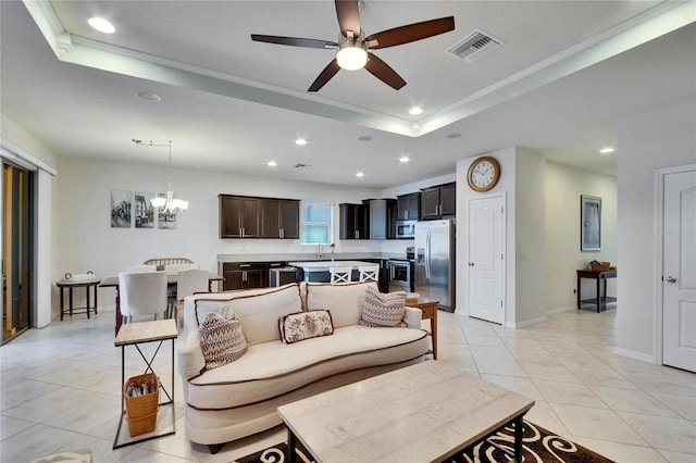 living room with light tile patterned floors, recessed lighting, a raised ceiling, visible vents, and ceiling fan with notable chandelier