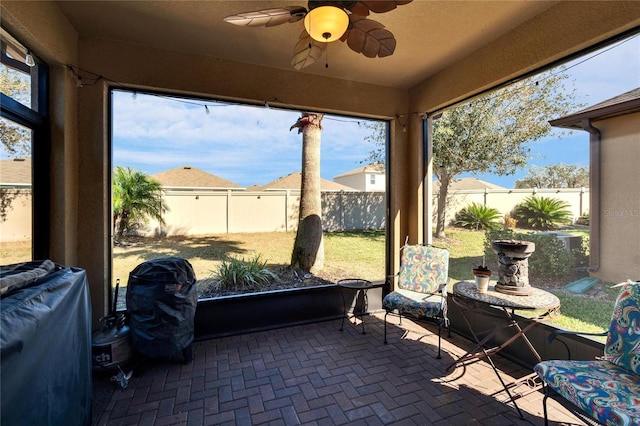 sunroom / solarium featuring a ceiling fan