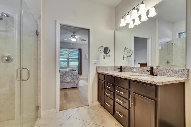 full bath with double vanity, connected bathroom, tile patterned floors, a shower stall, and a sink