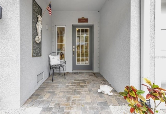 property entrance with stucco siding