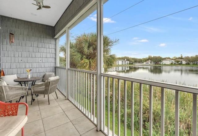 sunroom / solarium featuring a water view and ceiling fan