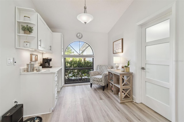 living area featuring lofted ceiling and light hardwood / wood-style flooring