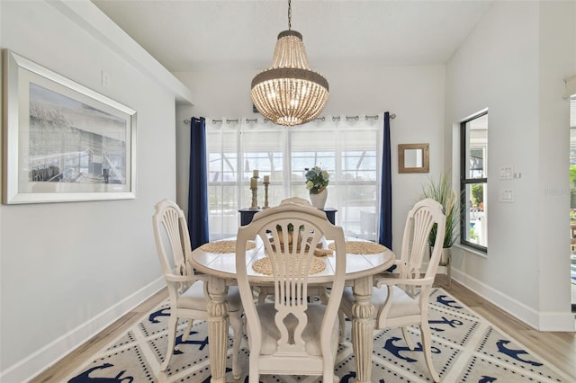 dining space featuring light hardwood / wood-style floors and a notable chandelier