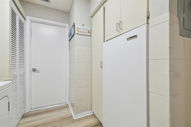 hallway featuring washer / clothes dryer and light wood-type flooring