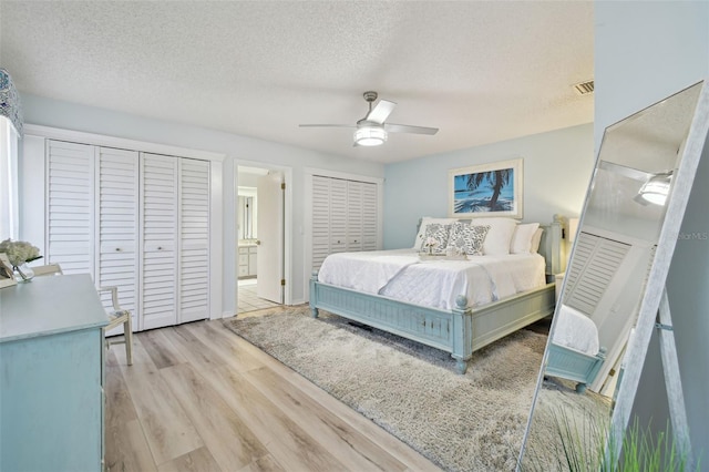 bedroom featuring ceiling fan, connected bathroom, a textured ceiling, and light hardwood / wood-style flooring