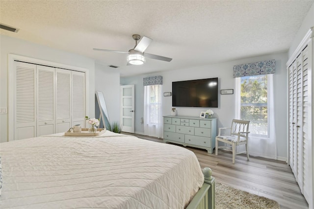 bedroom with ceiling fan, light hardwood / wood-style floors, a closet, and a textured ceiling