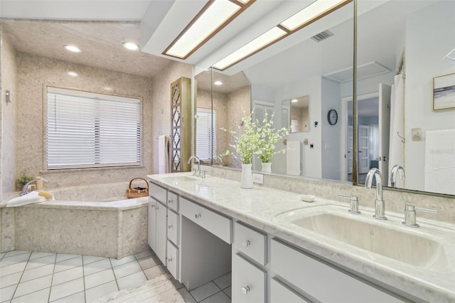 bathroom with a relaxing tiled tub, tile patterned floors, and vanity