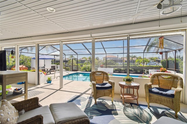 sunroom / solarium featuring a swimming pool and a wealth of natural light