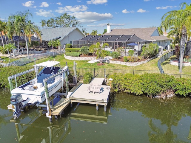 view of dock featuring a yard, a water view, and glass enclosure