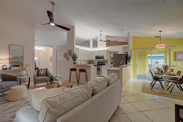 tiled living room with ceiling fan and lofted ceiling