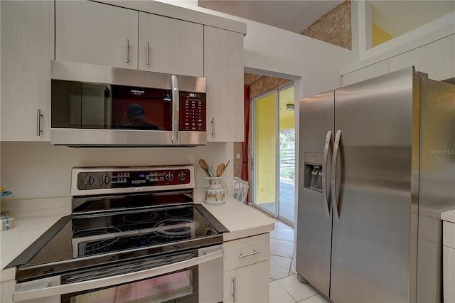 kitchen featuring stainless steel appliances and light tile patterned flooring