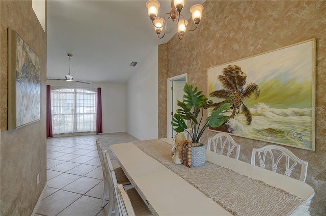 tiled dining space with ceiling fan with notable chandelier and high vaulted ceiling