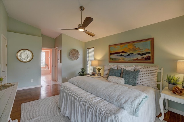 bedroom featuring hardwood / wood-style flooring, ensuite bathroom, lofted ceiling, and ceiling fan