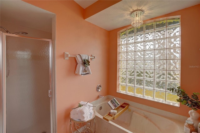 bathroom featuring shower with separate bathtub and a chandelier