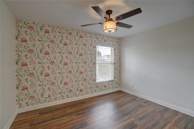 spare room with dark hardwood / wood-style floors and ceiling fan