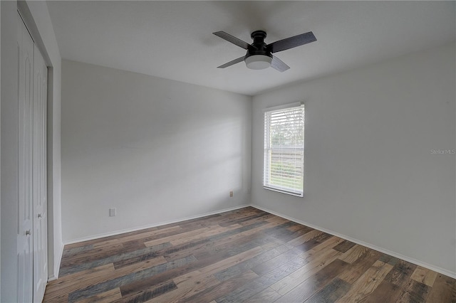 spare room with dark wood-type flooring and ceiling fan