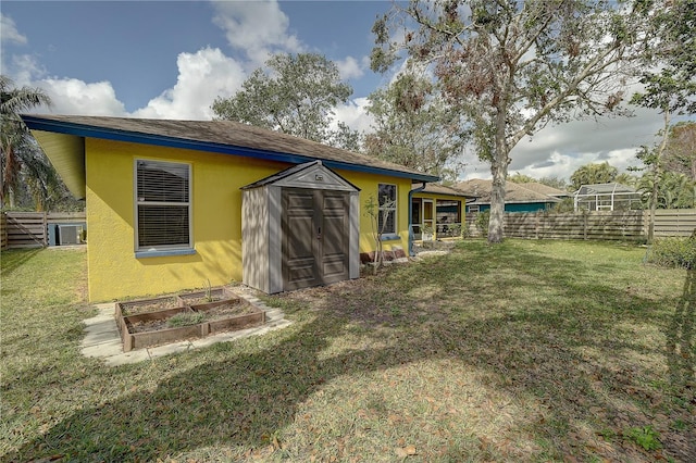 back of house featuring a lawn and a storage unit