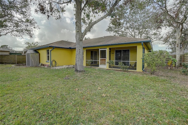 exterior space with a storage shed, a lawn, and a sunroom