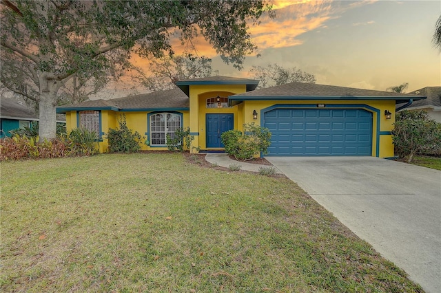 view of front of home with a yard and a garage