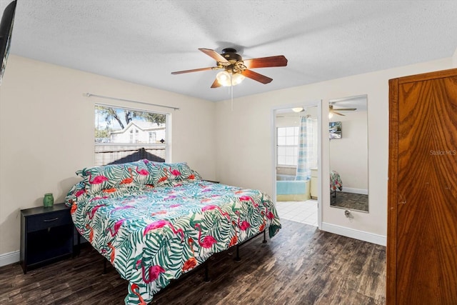 bedroom with ceiling fan, ensuite bath, dark wood-type flooring, and a textured ceiling