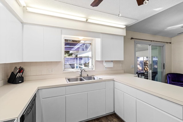 kitchen with sink, black dishwasher, white cabinets, ceiling fan, and backsplash