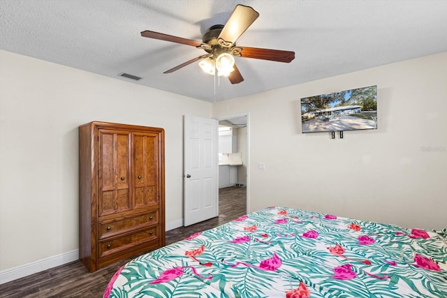 bedroom featuring ceiling fan, dark hardwood / wood-style flooring, and a textured ceiling