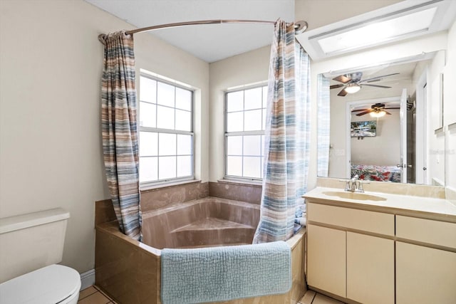 full bathroom featuring a skylight, vanity, shower / tub combo with curtain, and toilet