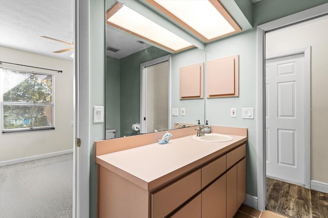 bathroom featuring vanity, toilet, and ceiling fan